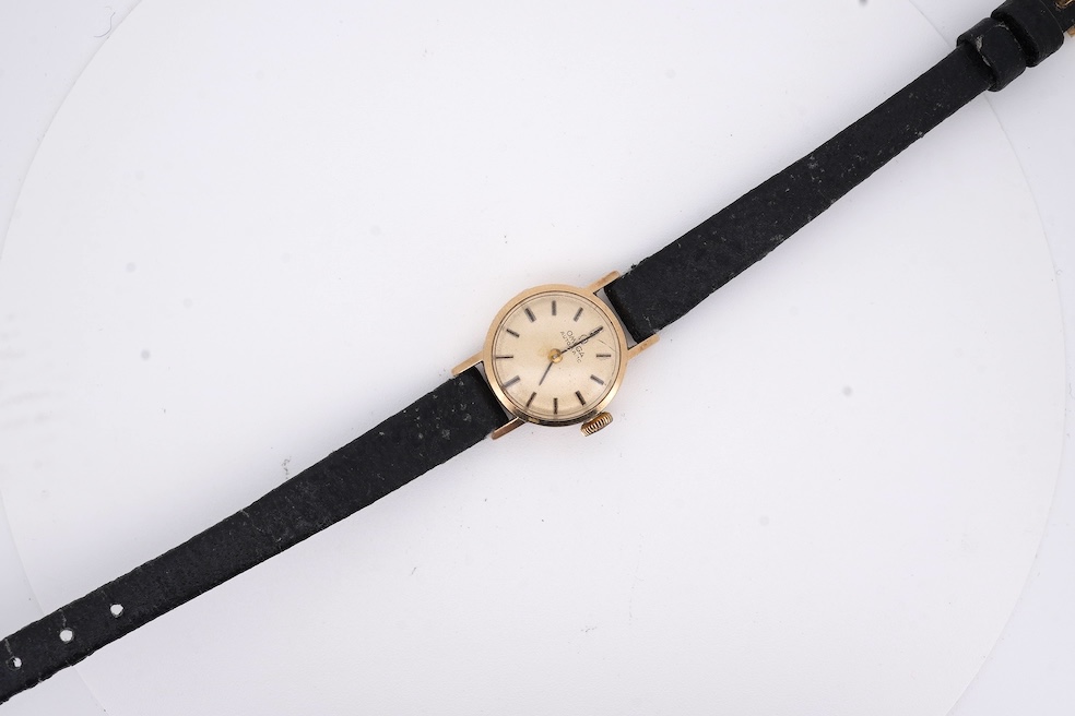 A lady's 9ct gold Omega Automatic wrist watch, on an associated leather strap, gross weight 11 grams. Condition - poor to fair